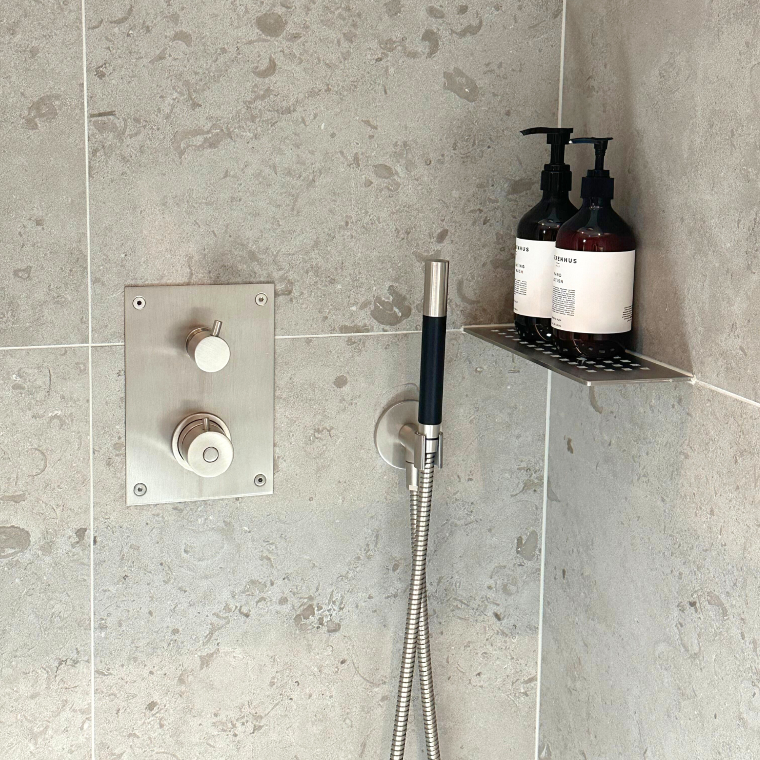 Dusch med grå beige vägg från Bricmate i Studio Badrum showroom